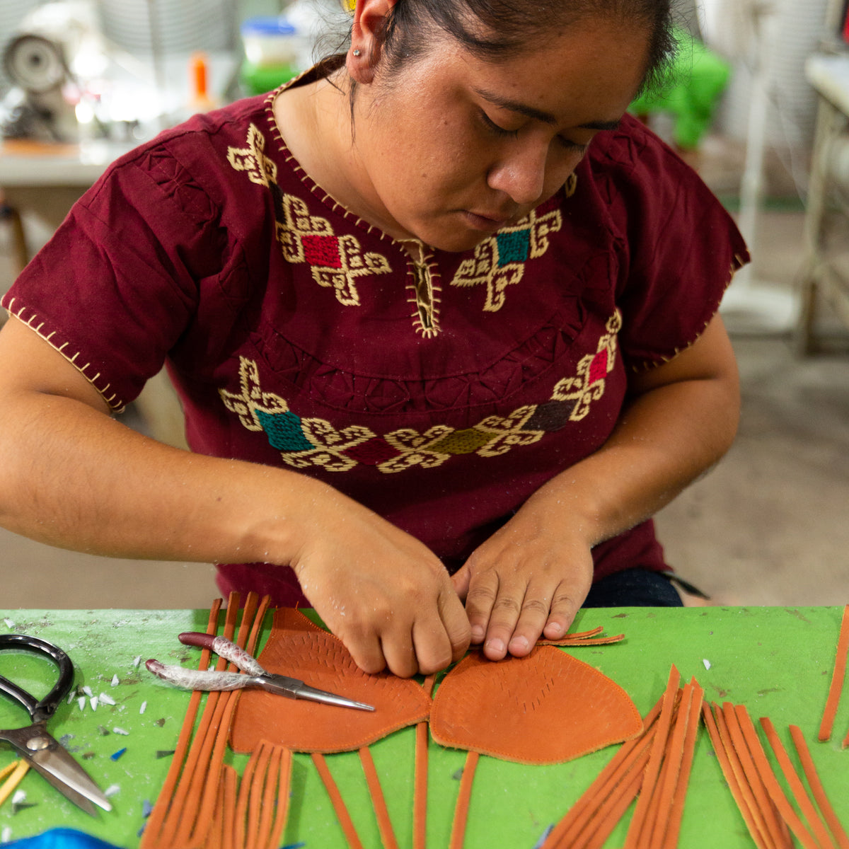 Artesana trabajando tiras de cuero para un huarache